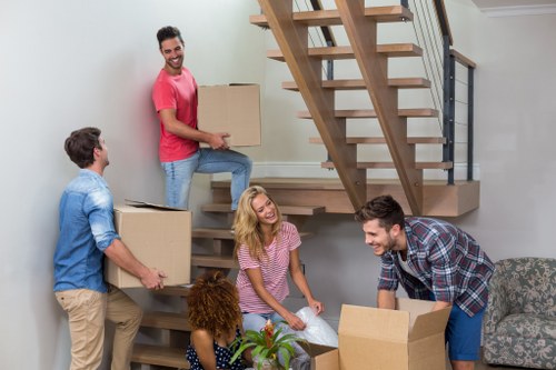 Removal team handling furniture in an Acton home move