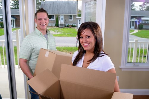 Packed boxes and furniture ready for a moving truck in Acton