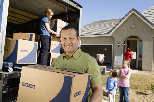Local movers transporting household items through an Acton street